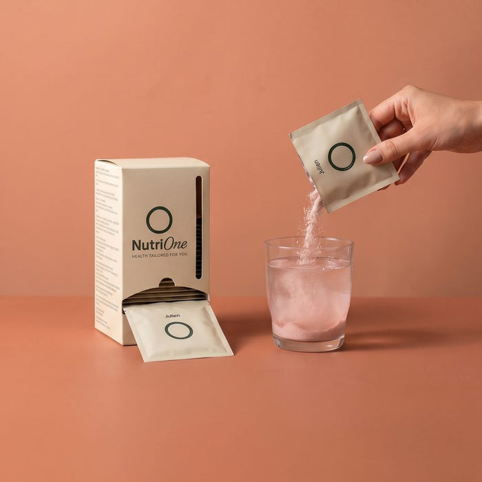 Un sachet NutriOne versé dans un grand verre d'eau